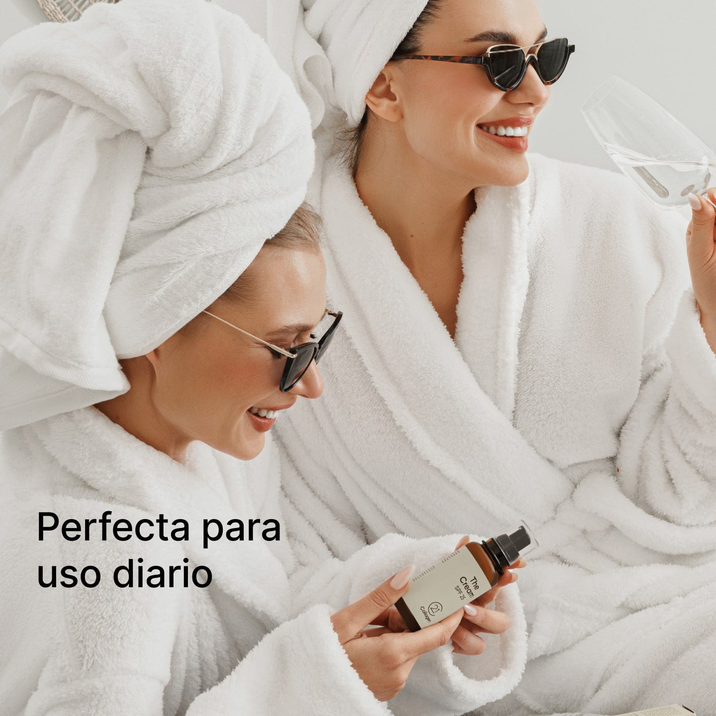 Dos mujeres sonrientes con batas blancas sostienen The Cream SPF 25 de 21Collagen – perfecta para el uso diario.
