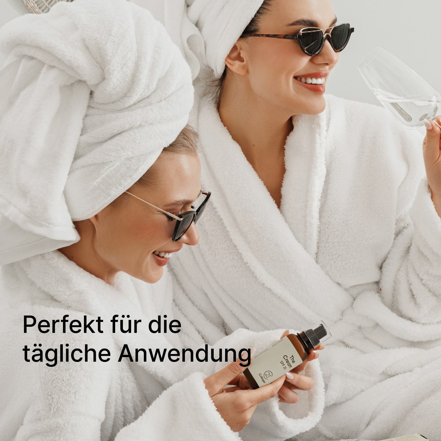 Zwei lächelnde Frauen in weißen Bademänteln halten The Cream SPF 25 von 21Collagen – perfekt für die tägliche Anwendung.