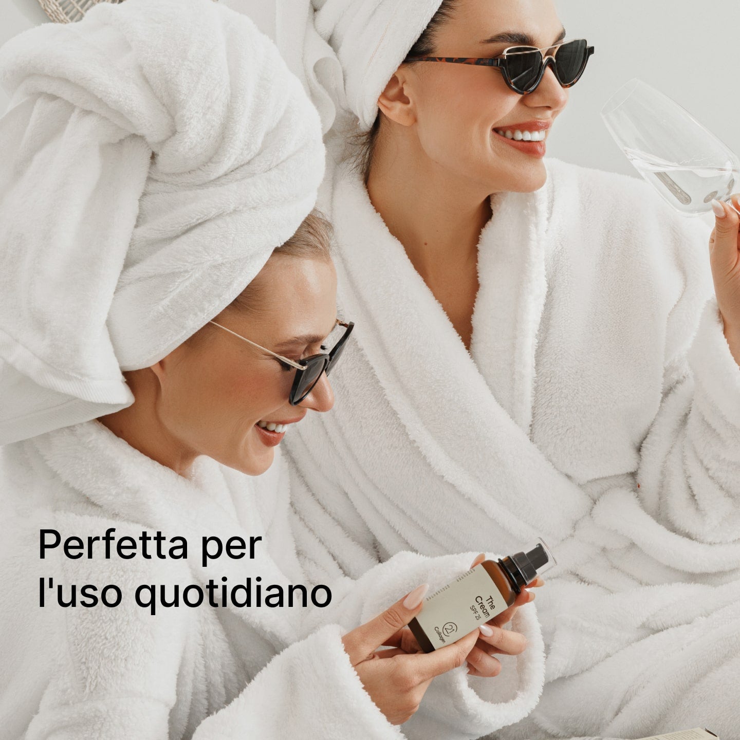 Due donne sorridenti in accappatoi bianchi, rilassate, tengono The Cream SPF 25 di 21Collagen – perfetta per l’uso quotidiano.